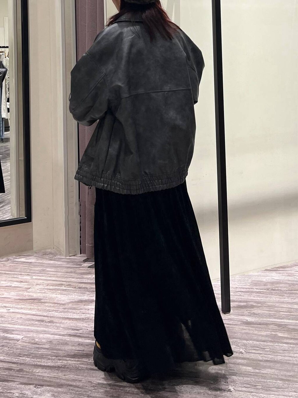 ブラック系のデニムパンツ、ブラウン系のブーツ、グレー系のブルゾンを着用したレディースの秋コーディネートの4枚目の写真