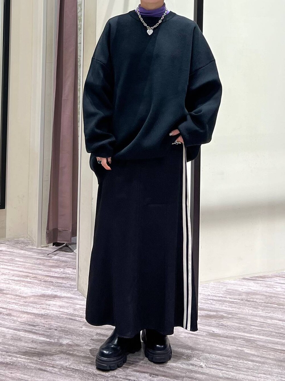 ブラック系のニット/セーター、パープル系のTシャツ/カットソー、ブラック系のスニーカーを着用したレディースの冬コーディネートの7枚目の写真