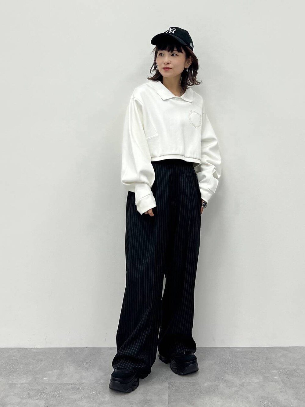 ブラック系のキャミソール、ブラック系のスラックス、ブラック系のスニーカーを着用したレディースの冬コーディネートの6枚目の写真