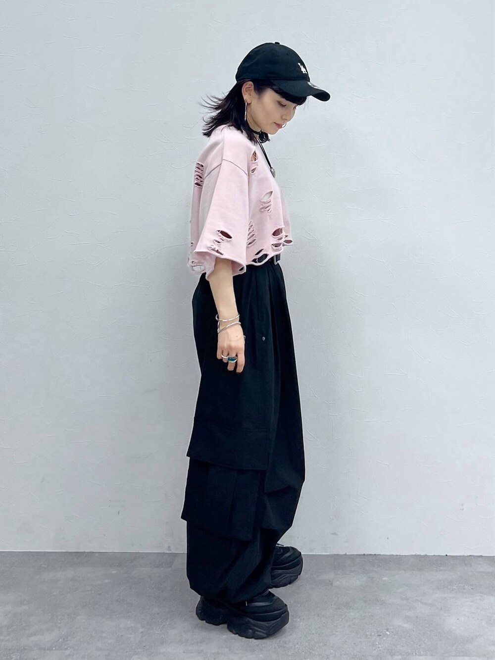 ブラック系のカーゴパンツ、ブラック系のスニーカー、ピンク系のTシャツ/カットソーを着用したレディースの秋コーディネートの3枚目の写真