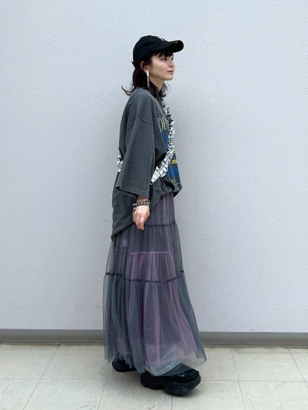 ブラック系のスニーカー、グレー系のスカート、ブルー系のデニムパンツを着用したレディースの夏コーディネートの4枚目の写真