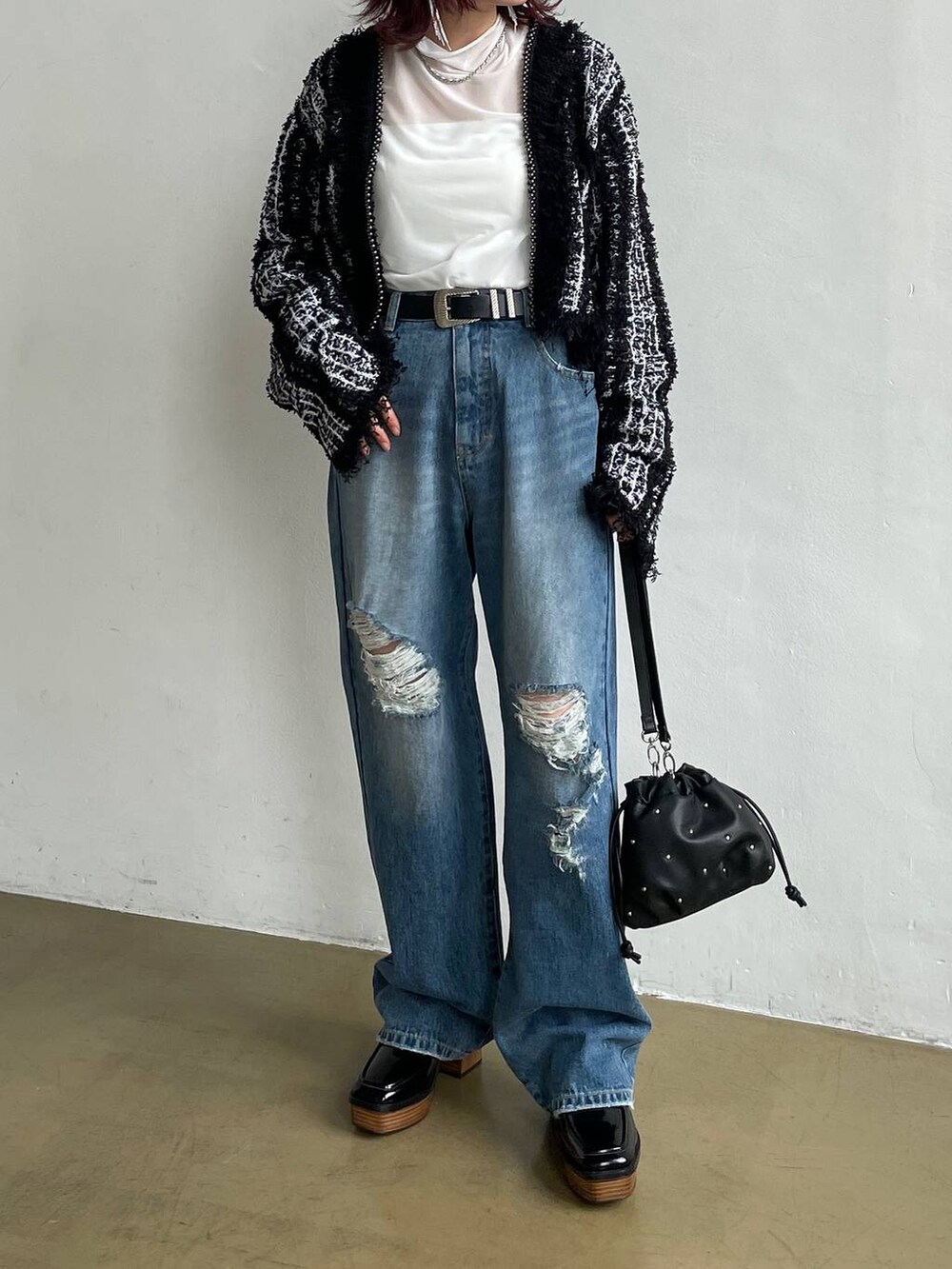 ブルー系のデニムパンツ、ブラック系のカーディガン/ボレロ、ホワイト系のTシャツ/カットソーを着用したレディースの秋コーディネートの4枚目の写真