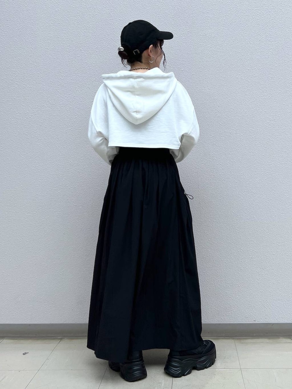 ブラック系のキャミソール、ブラック系のスニーカー、ホワイト系のパーカーを着用したレディースの秋コーディネートの4枚目の写真