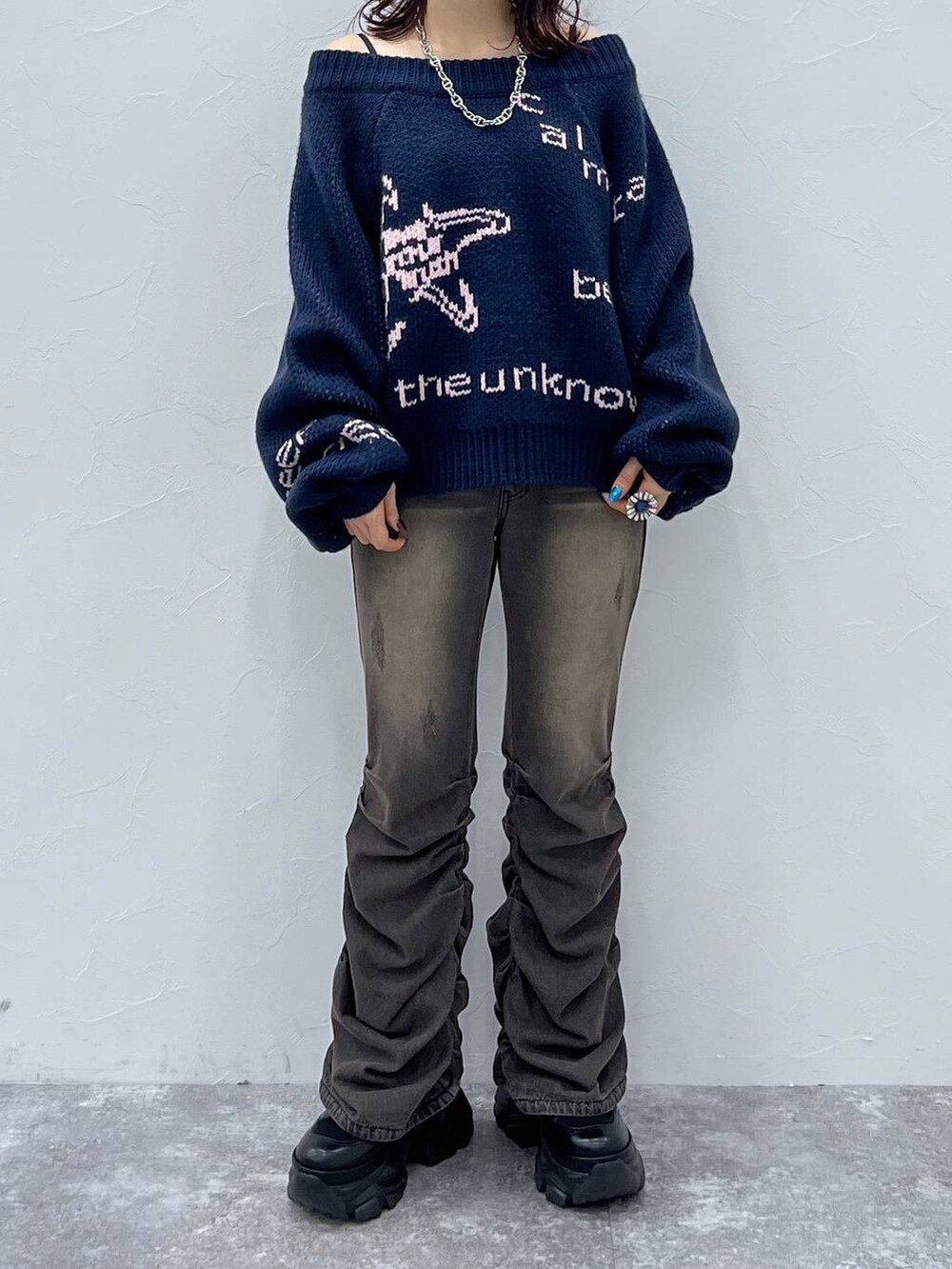 ブラック系のデニムパンツ、ブラック系のブーツ、ブルー系のニット/セーターを着用したレディースの冬コーディネートの5枚目の写真