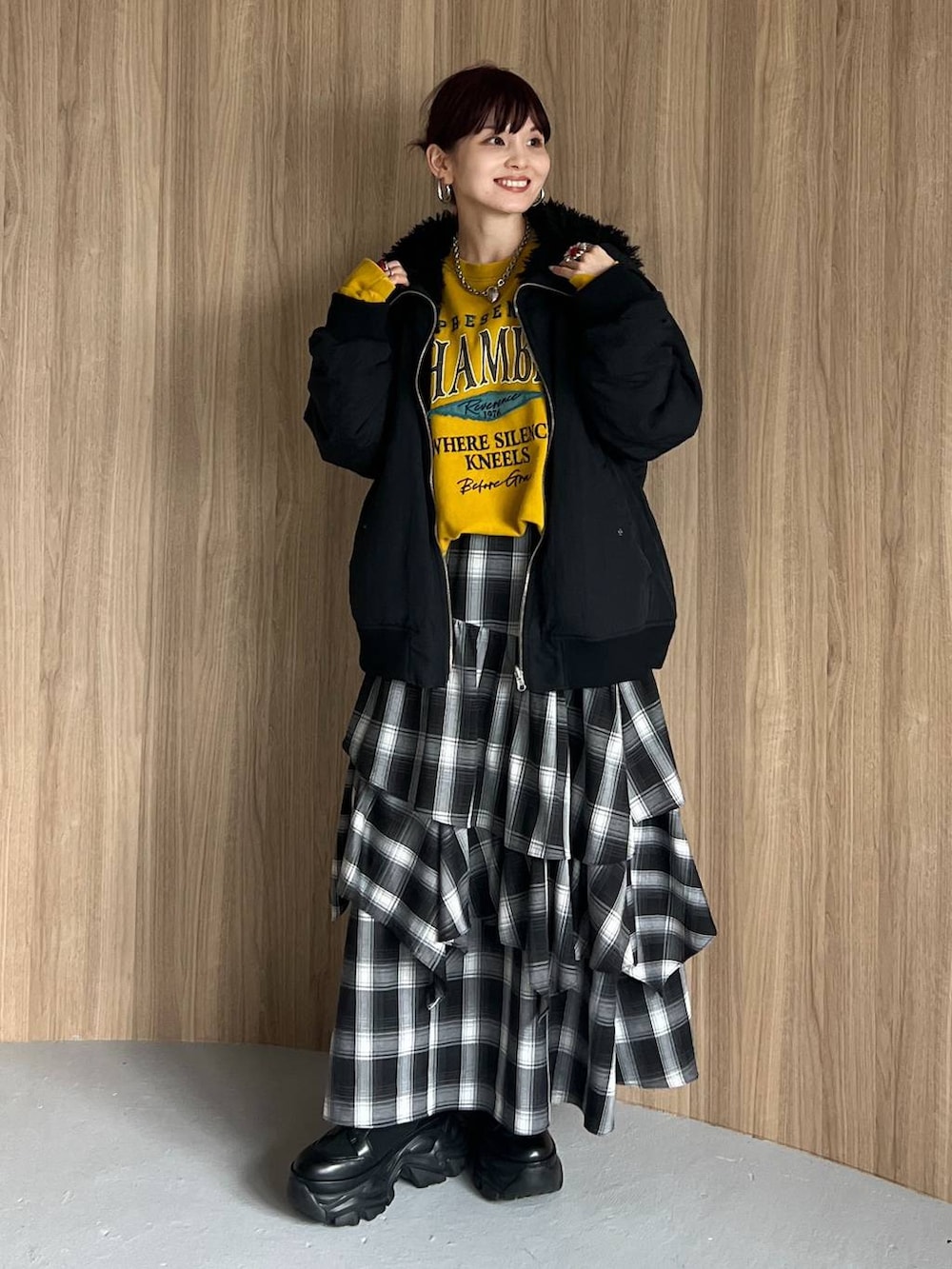 ブラック系のブーツ、イエロー系のスウェット、ブラック系のブルゾンを着用したレディースの秋コーディネートの2枚目の写真