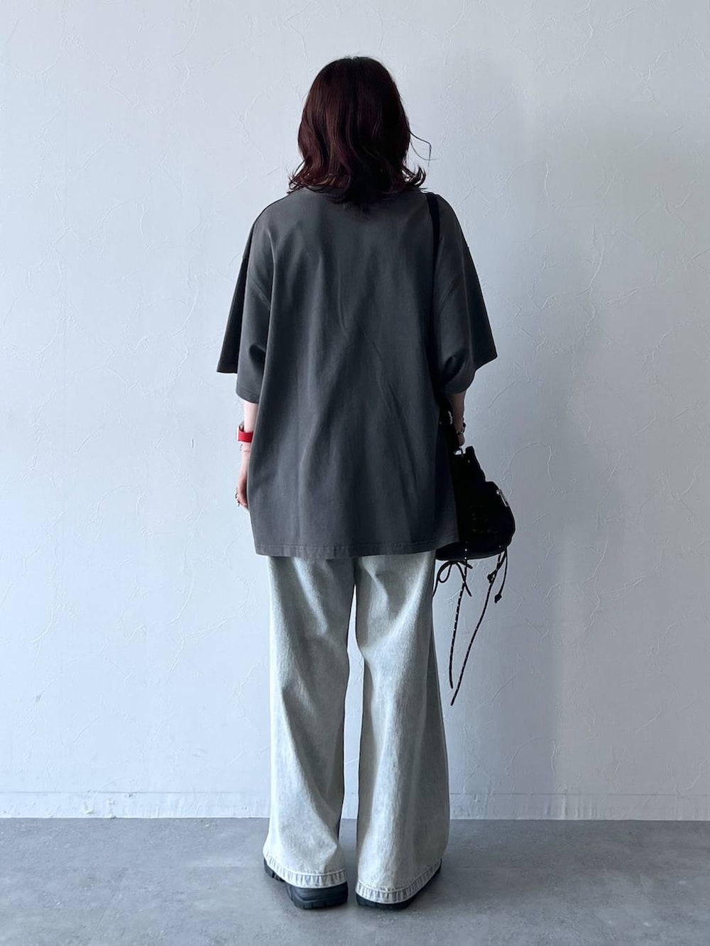 ブラック系のスニーカー、ブルー系のデニムパンツ、グレー系のTシャツ/カットソーを着用したレディースの夏コーディネートの4枚目の写真