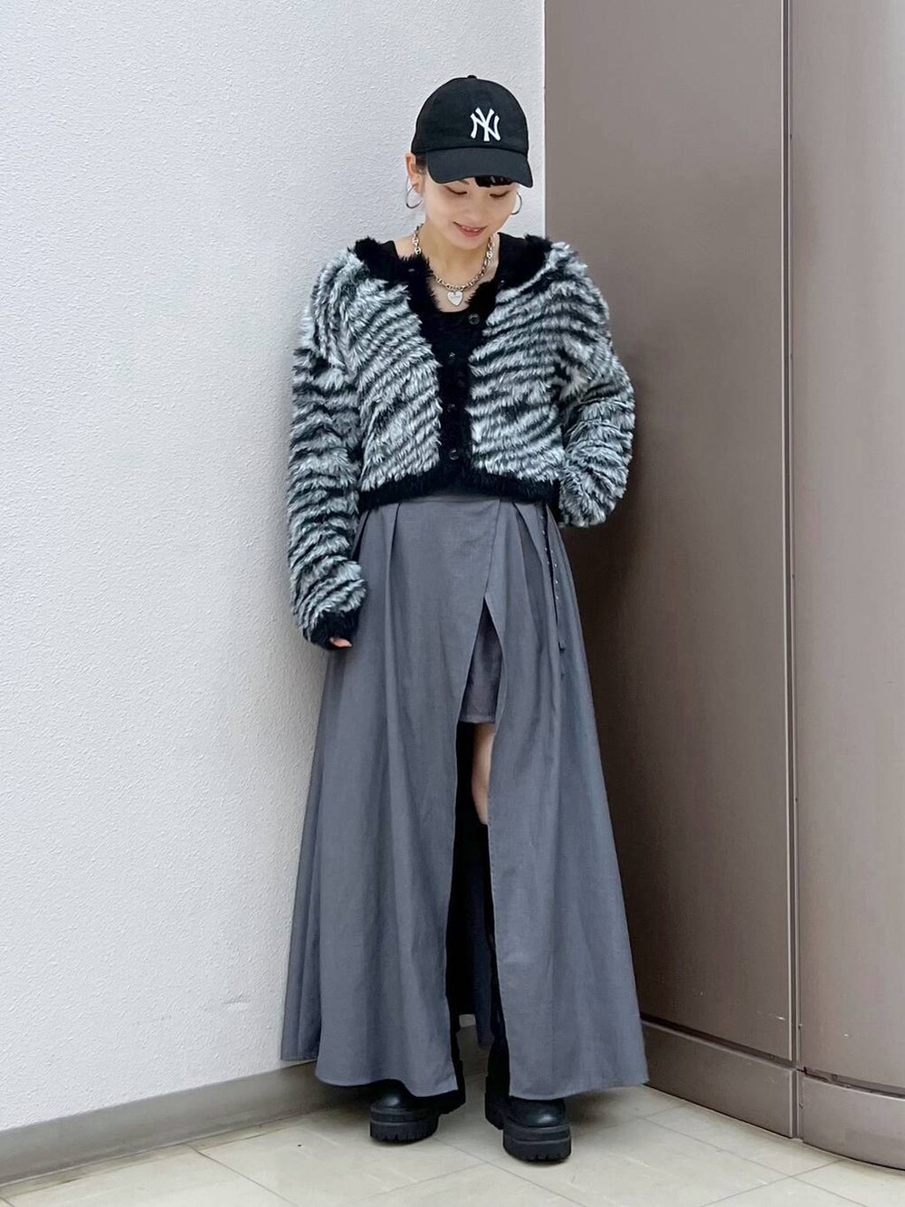 ブラック系のブーツ、グレー系のスカート、その他のカーディガン/ボレロを着用したレディースの秋コーディネートの5枚目の写真