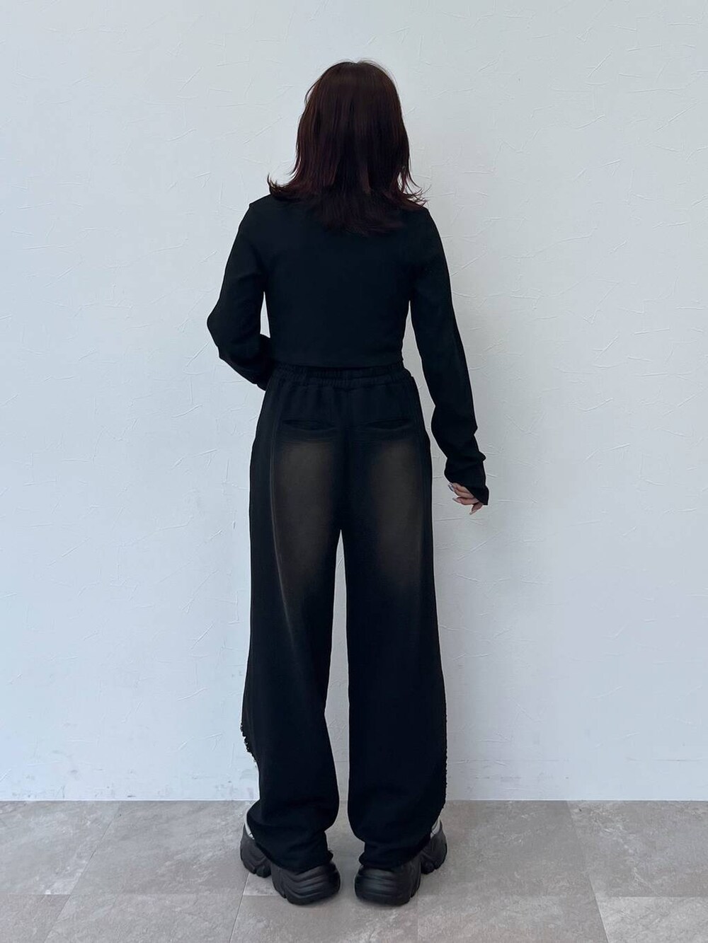 グレー系のスニーカー、ブラック系のスウェットパンツ、ブラック系のTシャツ/カットソーを着用したレディースの秋コーディネートの3枚目の写真