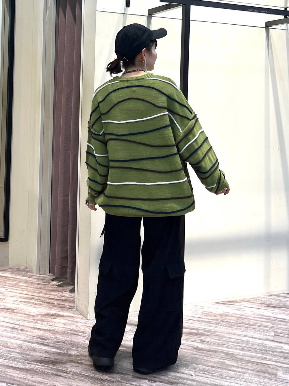 ブラック系のカーゴパンツ、グリーン系のニット/セーター、ブラック系のブーツを着用したレディースの冬コーディネートの5枚目の写真