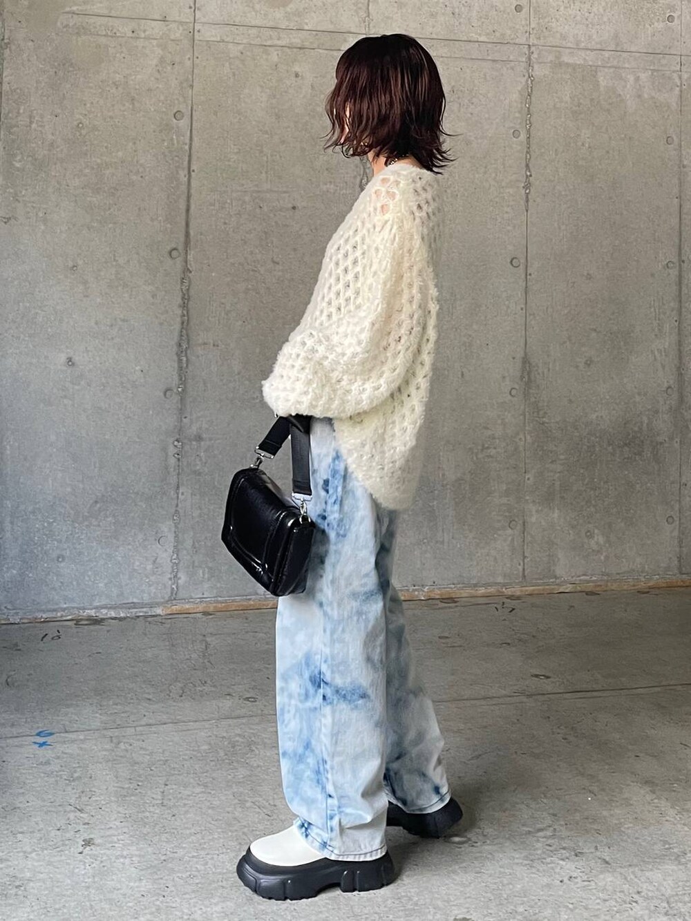 ブルー系のデニムパンツ、ホワイト系のブーツ、ホワイト系のニット/セーターを着用したレディースの秋コーディネートの4枚目の写真