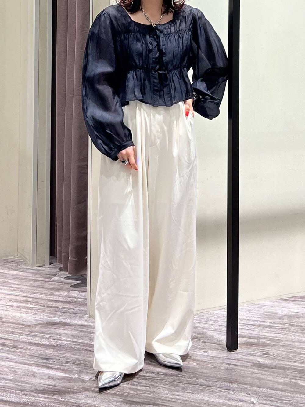 シルバー系のパンプス、ホワイト系のスラックス、ブラック系のシャツ/ブラウスを着用したレディースの春コーディネートの4枚目の写真