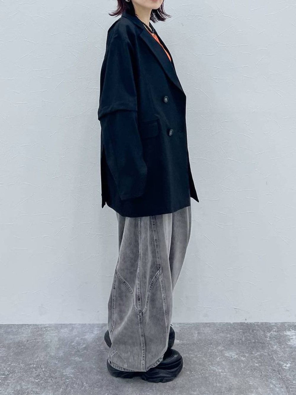 ブラック系のブーツ、ブラック系のテーラードジャケット、ブラック系のデニムパンツを着用したレディースの春コーディネートの3枚目の写真