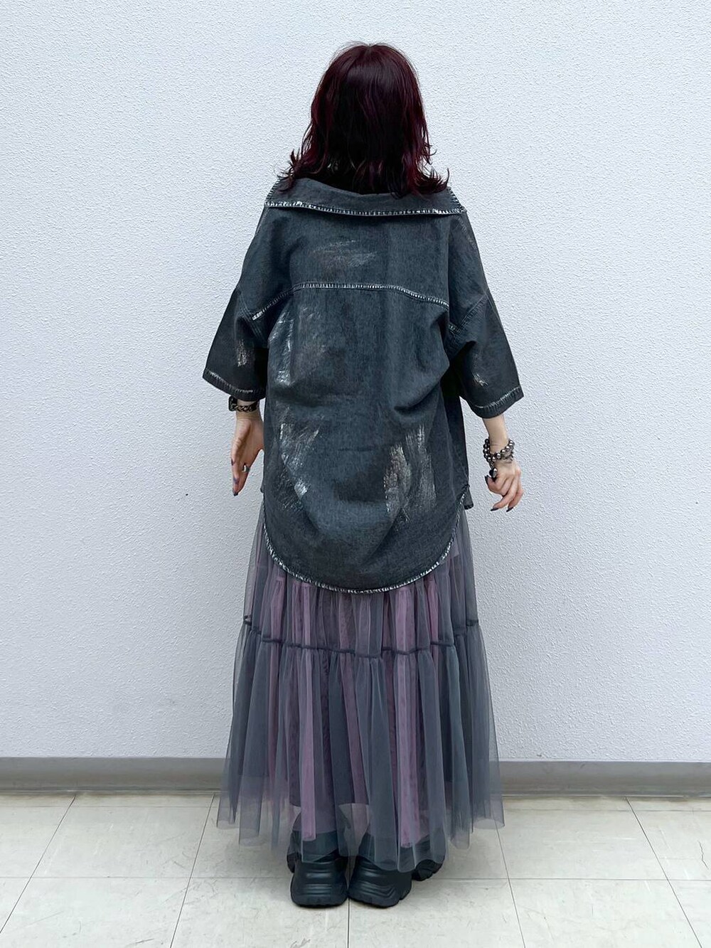 ブラック系のスニーカー、グレー系のスカート、ブラック系のシャツ/ブラウスを着用したレディースの夏コーディネートの4枚目の写真