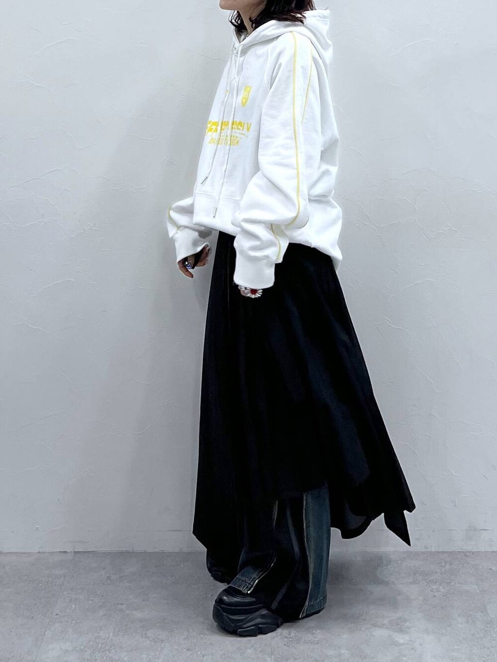 ブラック系のブーツ、ブルー系のデニムパンツ、ブラック系のスカートを着用したレディースの冬コーディネートの4枚目の写真