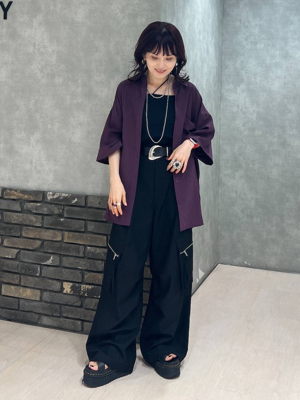 ブラック系のカーゴパンツ、レッド系のシャツ/ブラウス、ブラック系のベルトを着用したレディースの秋コーディネートの2枚目の写真