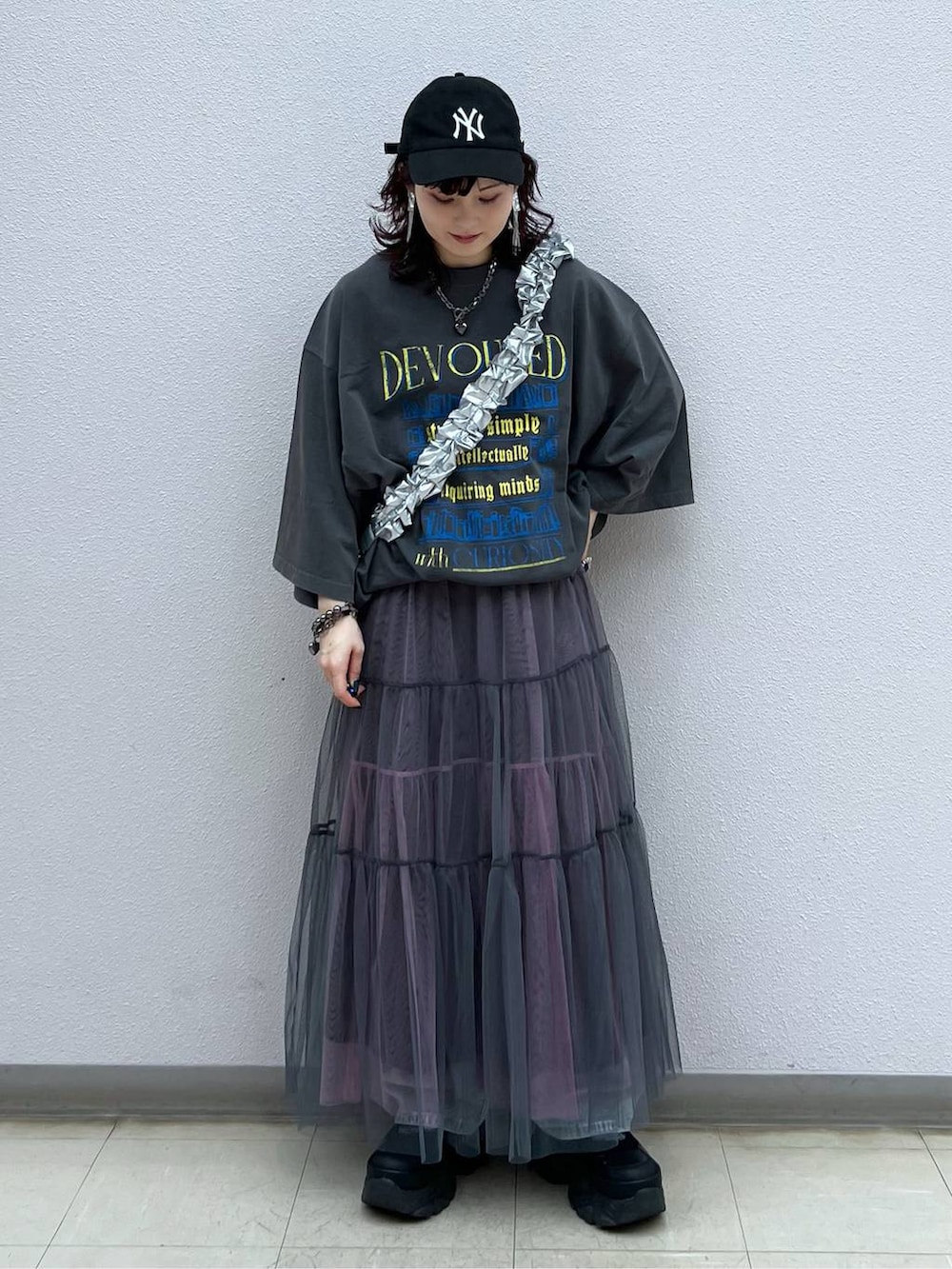 ブラック系のスニーカー、グレー系のスカート、ブルー系のデニムパンツを着用したレディースの夏コーディネートの2枚目の写真