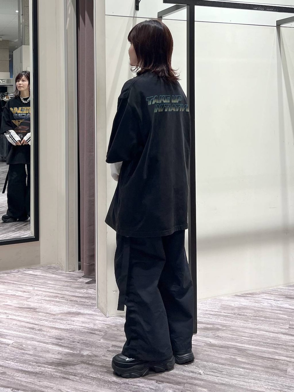 ブラック系のスニーカー、ブラック系のカーゴパンツ、ブラック系のTシャツ/カットソーを着用したレディースの春コーディネートの3枚目の写真