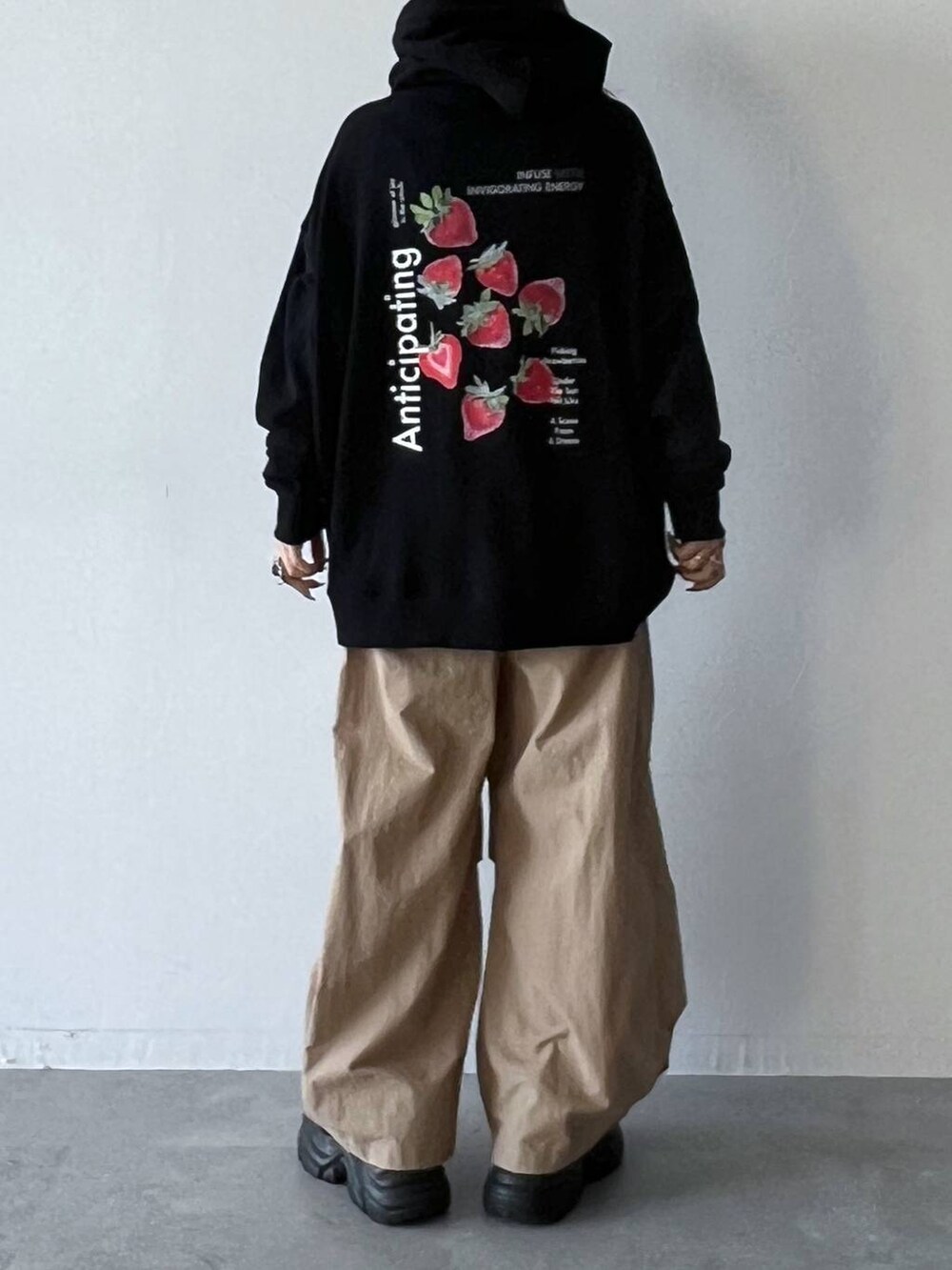 ブラック系のスニーカー、ベージュ系のカーゴパンツ、ブラック系のパーカーを着用したレディースの夏コーディネートの4枚目の写真