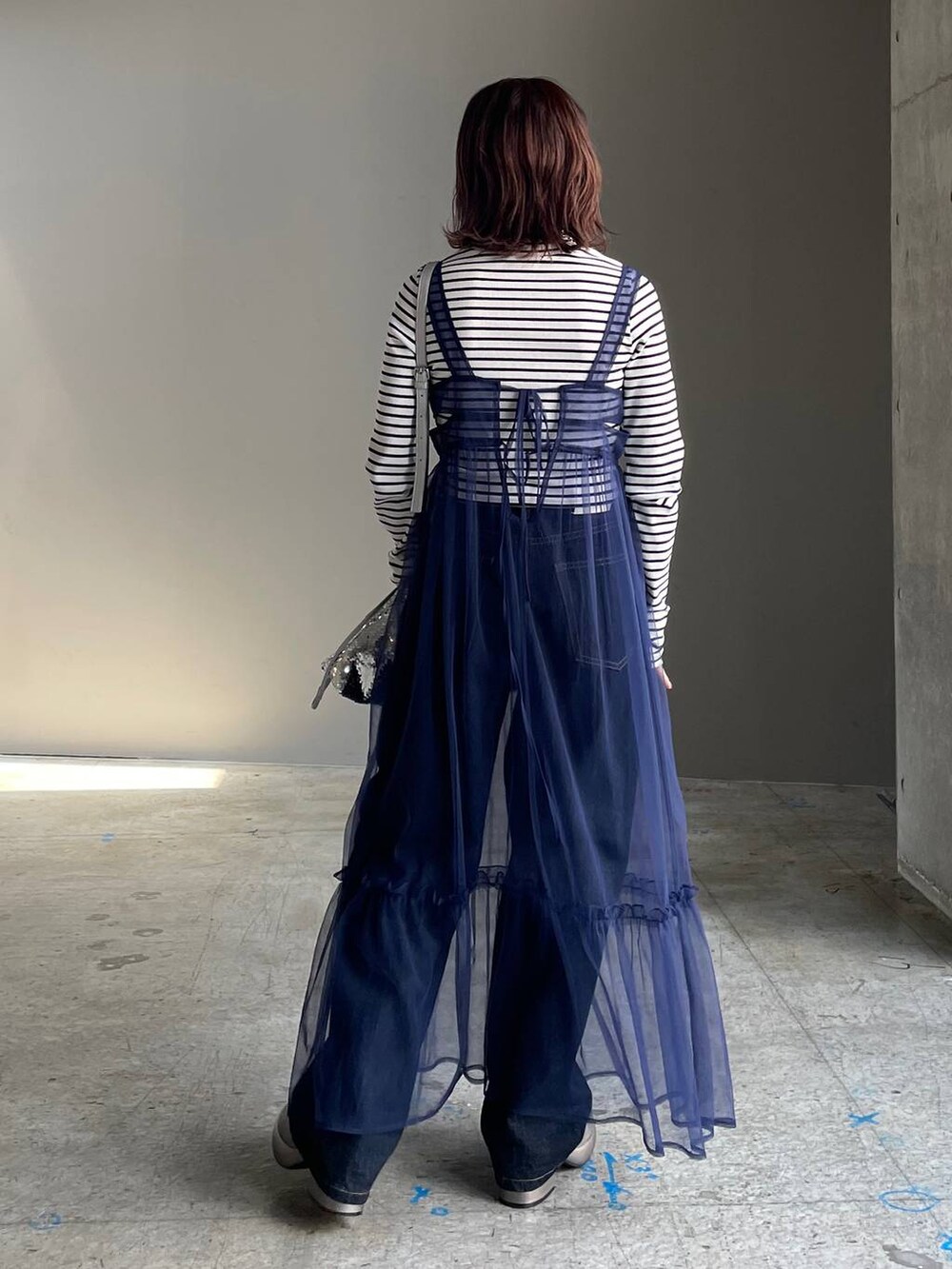 ブルー系のデニムパンツ、その他のブーツ、ブルー系のワンピースを着用したレディースの秋コーディネートの3枚目の写真