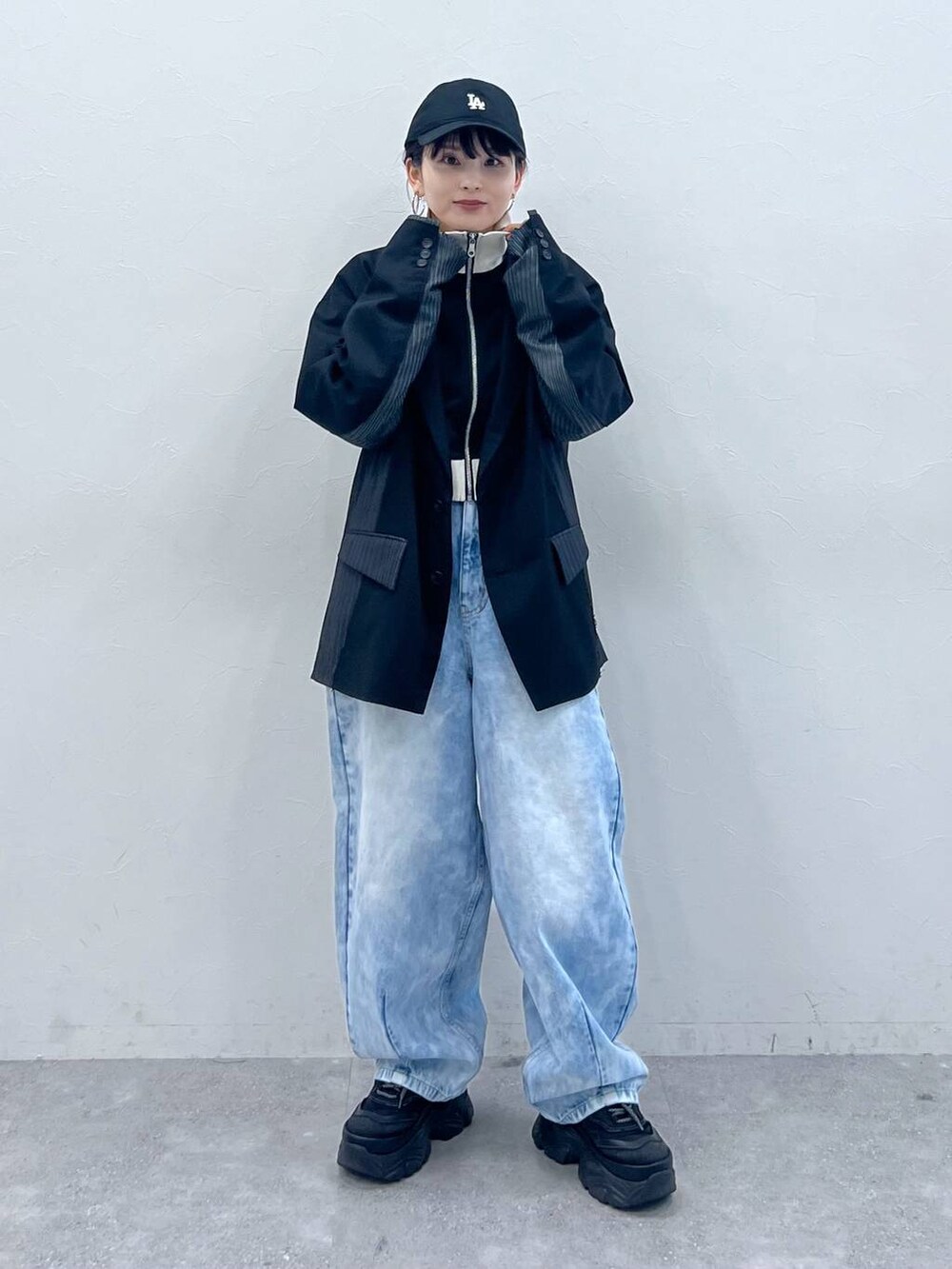 ブラック系のテーラードジャケット、ブラック系のスニーカー、ブラック系のジャージを着用したレディースの春コーディネートの2枚目の写真