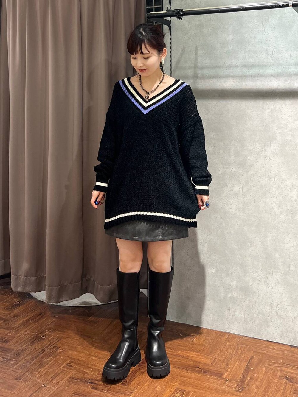 ブラック系のニット/セーター、ブラック系のスカート、ブラック系のブーツを着用したレディースの秋コーディネートの2枚目の写真