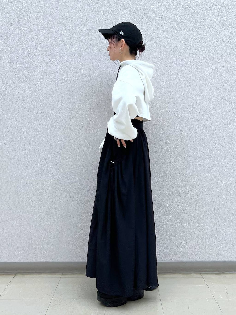 ブラック系のキャミソール、ブラック系のスニーカー、ホワイト系のパーカーを着用したレディースの秋コーディネートの3枚目の写真