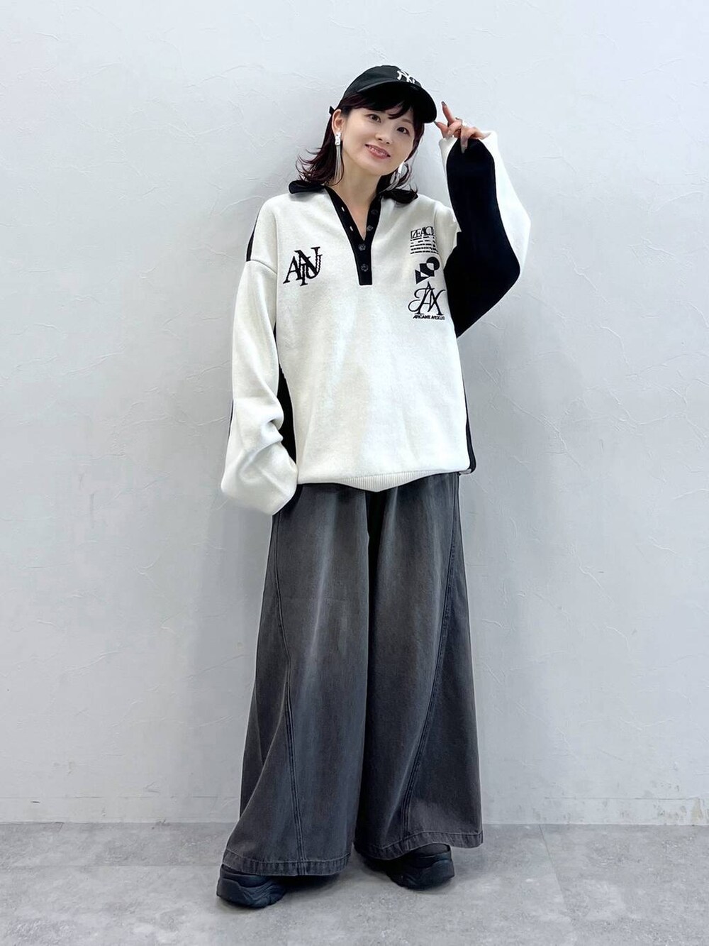 ブラック系のデニムパンツ、ブラック系のニット/セーター、ブラック系のスニーカーを着用したレディースの秋コーディネートの8枚目の写真