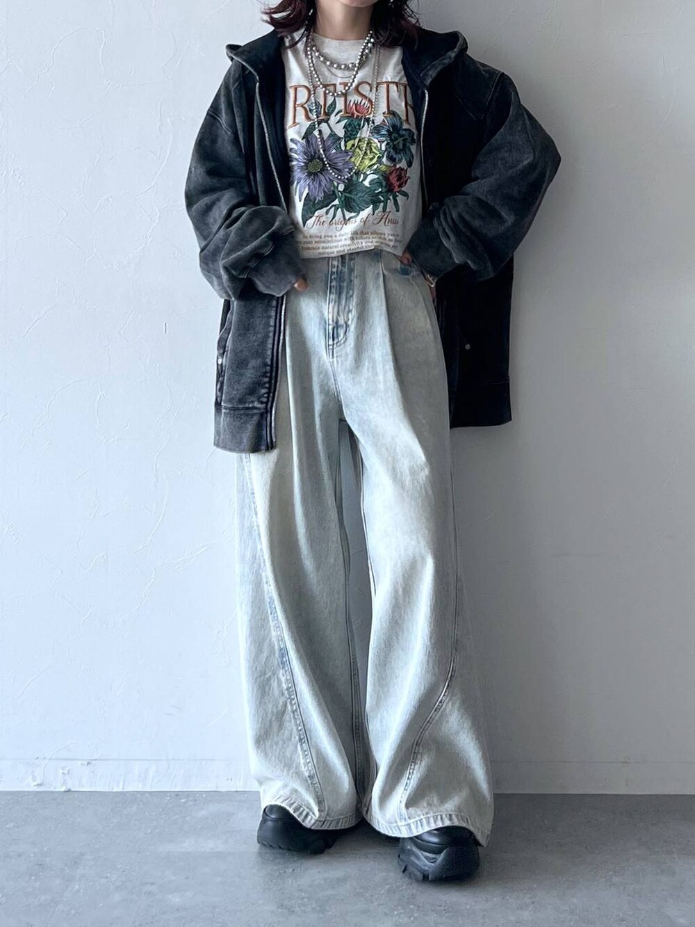 ブラック系のスニーカー、ブルー系のデニムパンツ、ベージュ系のTシャツ/カットソーを着用したレディースの秋コーディネートの5枚目の写真
