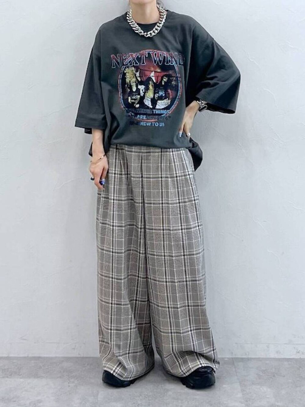 ブラック系のスニーカー、グレー系のTシャツ/カットソー、ベージュ系のスラックスを着用したレディースの秋コーディネートの5枚目の写真