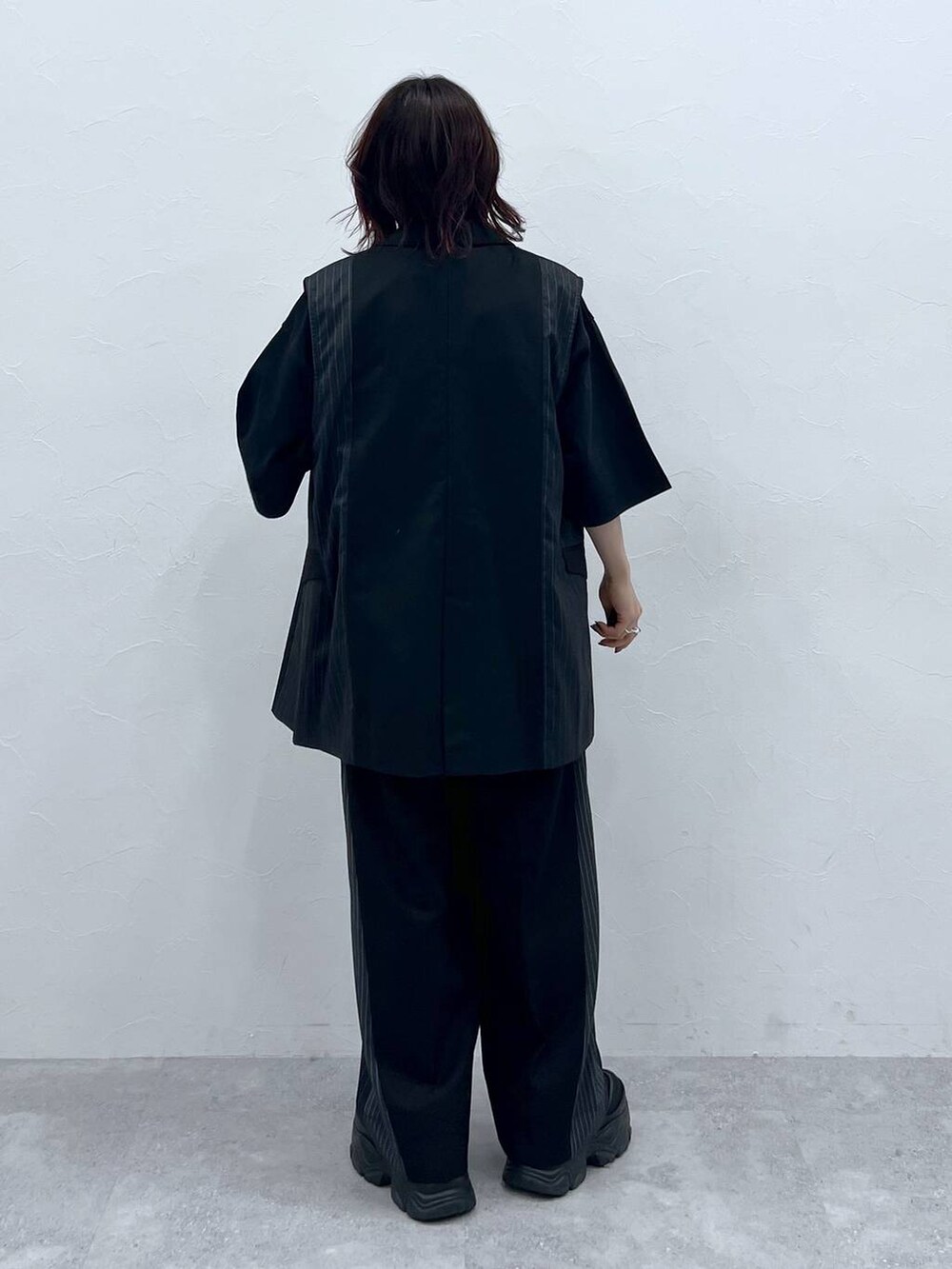 ブラック系のスラックス、ブラック系のTシャツ/カットソー、ブラック系のスニーカーを着用したレディースの春コーディネートの4枚目の写真