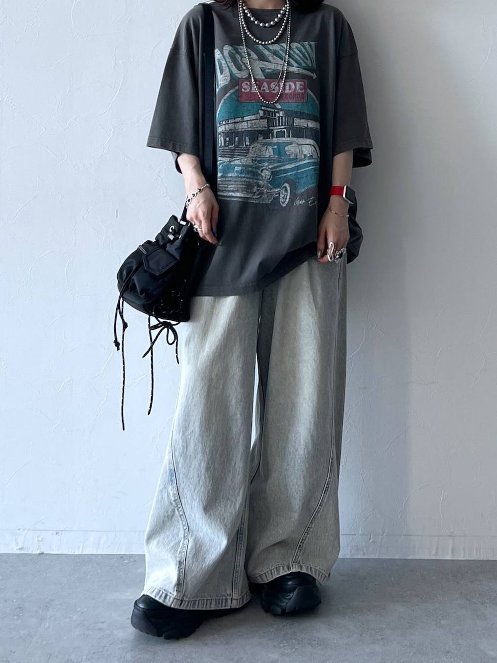 ブラック系のスニーカー、ブルー系のデニムパンツ、グレー系のTシャツ/カットソーを着用したレディースの夏コーディネートの6枚目の写真