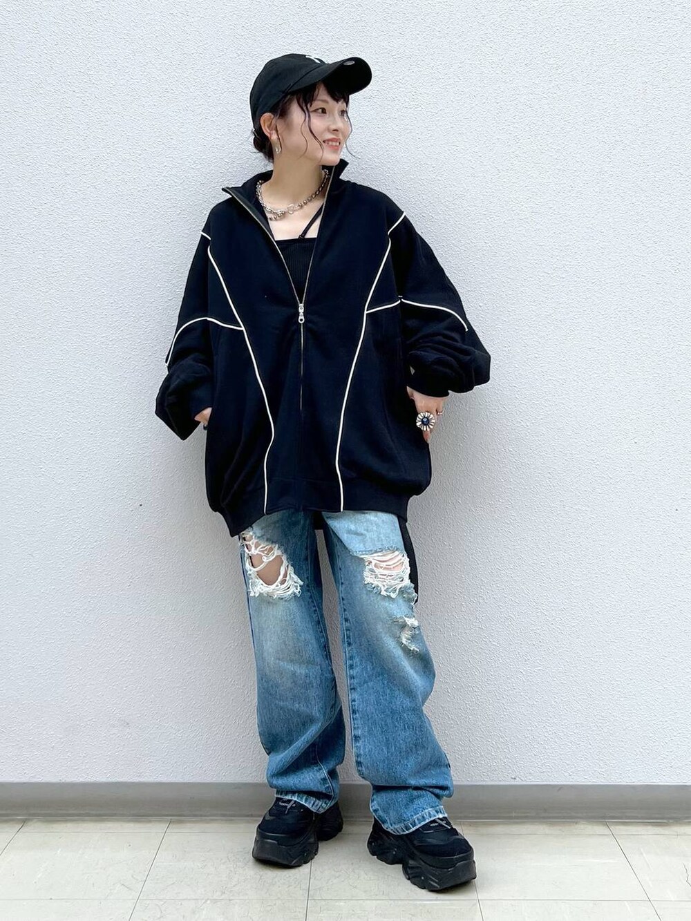 ブラック系のキャミソール、ブルー系のデニムパンツ、ブラック系のスニーカーを着用したレディースの春コーディネートの8枚目の写真