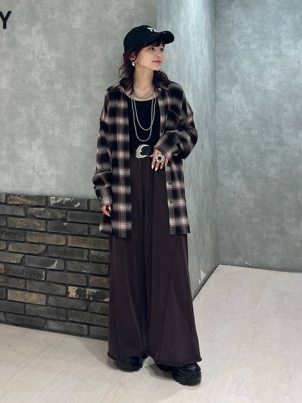 ブラック系のブーツ、ブラウン系のスウェットパンツ、ブラウン系のシャツ/ブラウスを着用したレディースの秋コーディネートの2枚目の写真