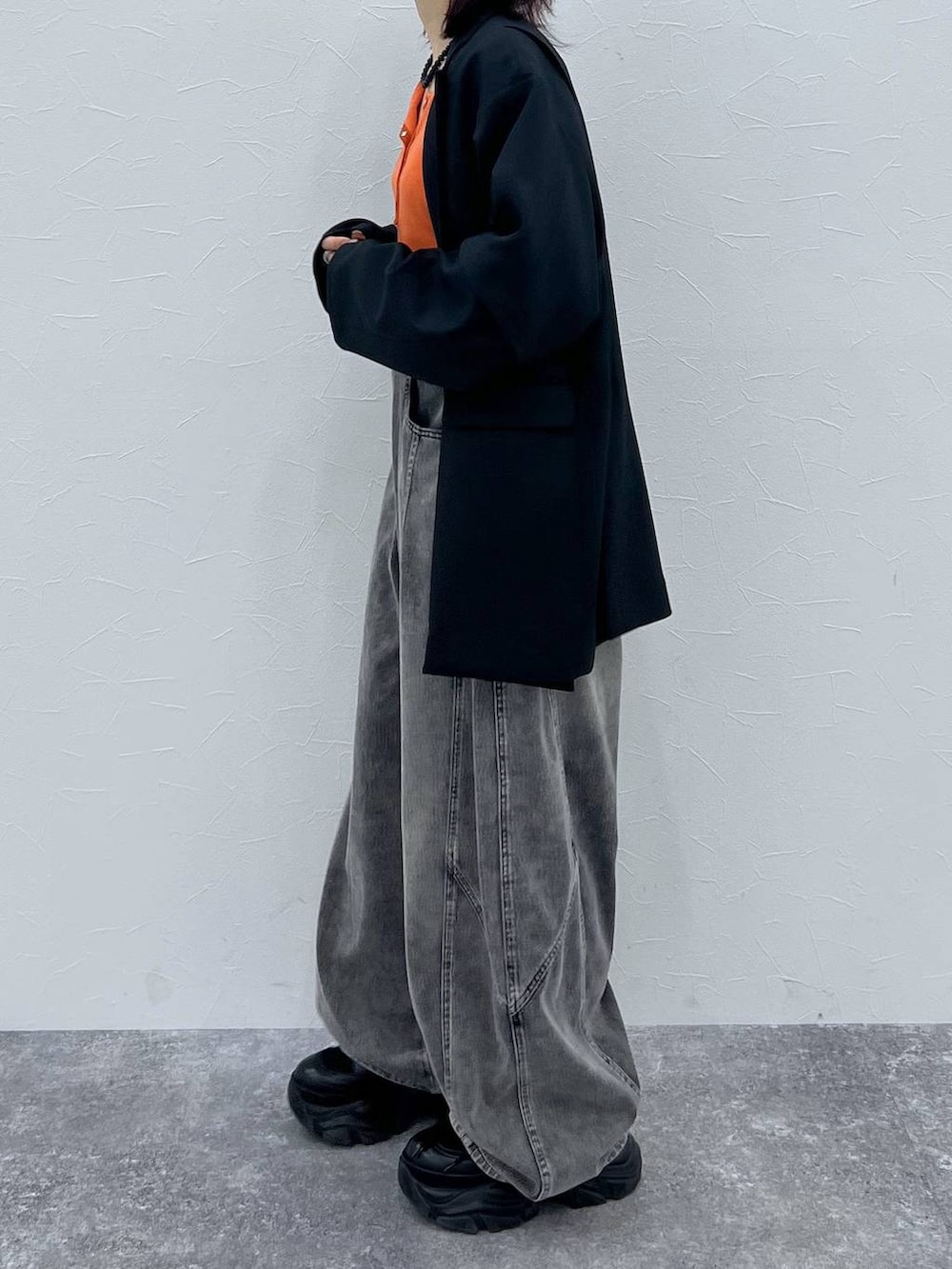 ブラック系のブーツ、ブラック系のテーラードジャケット、ブラック系のデニムパンツを着用したレディースの春コーディネートの4枚目の写真