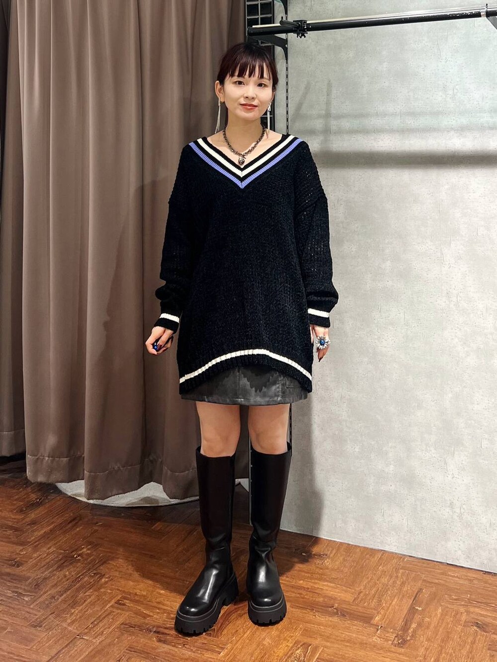 ブラック系のニット/セーター、ブラック系のスカート、ブラック系のブーツを着用したレディースの秋コーディネートの6枚目の写真
