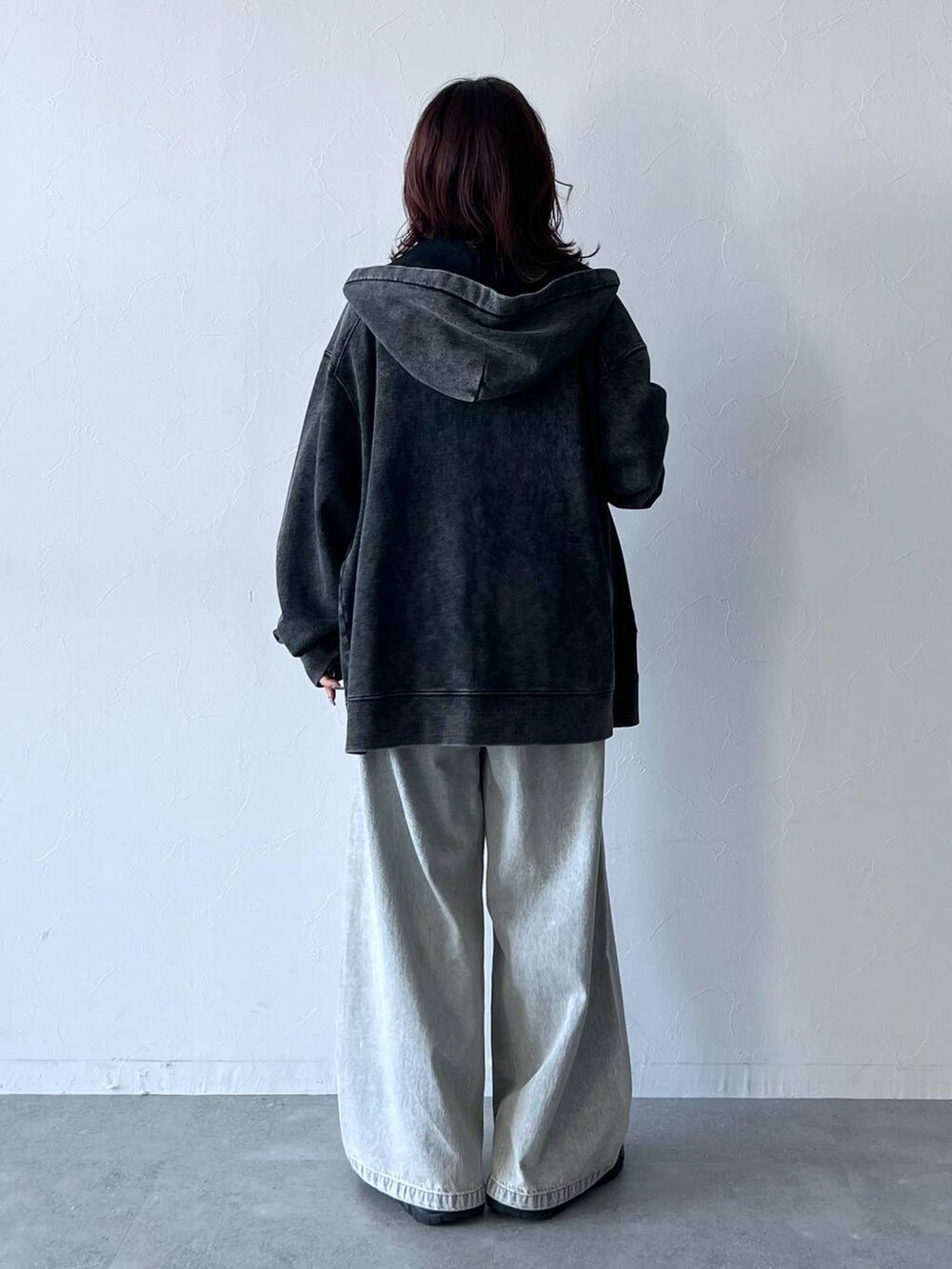 ブラック系のスニーカー、ブルー系のデニムパンツ、ベージュ系のTシャツ/カットソーを着用したレディースの秋コーディネートの4枚目の写真