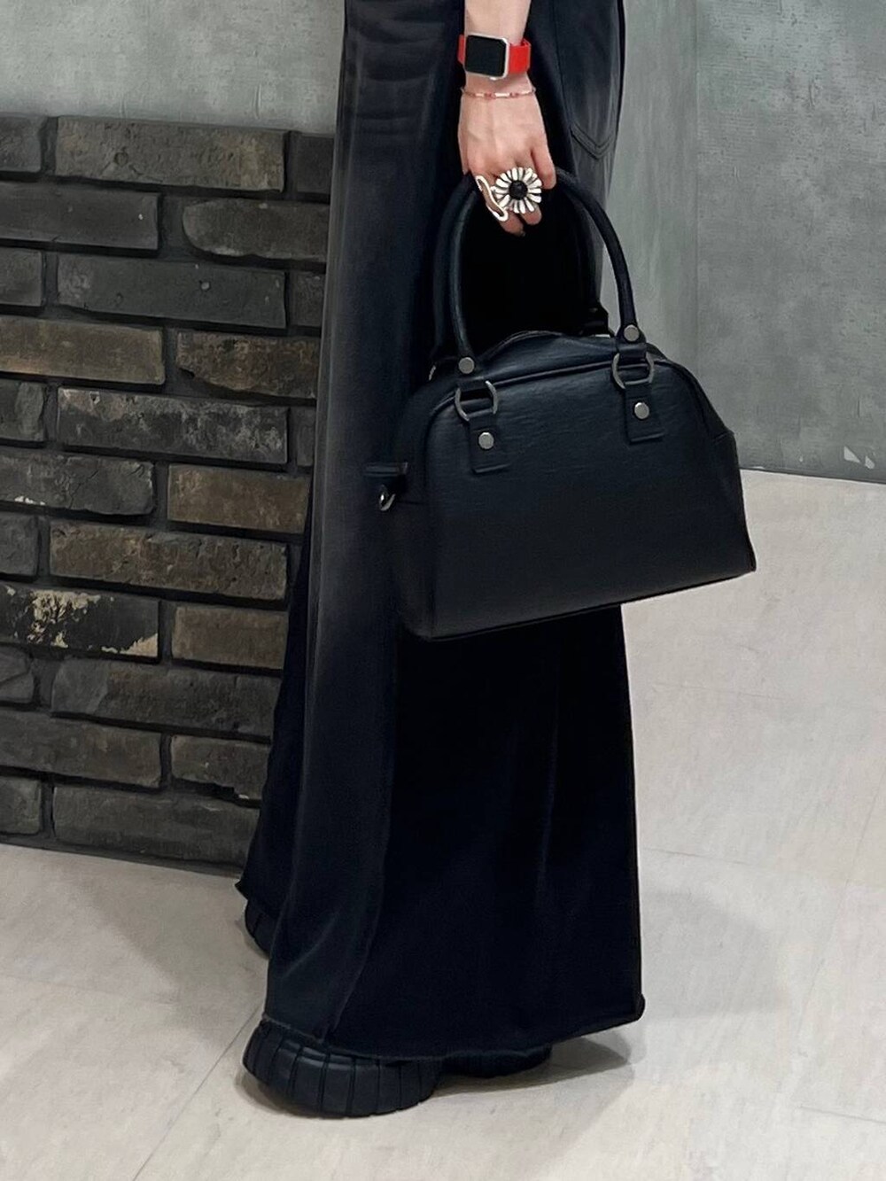 ブラック系のデニムパンツ、ブラック系のショルダーバッグ、ホワイト系のベストを着用したレディースの夏コーディネートの5枚目の写真