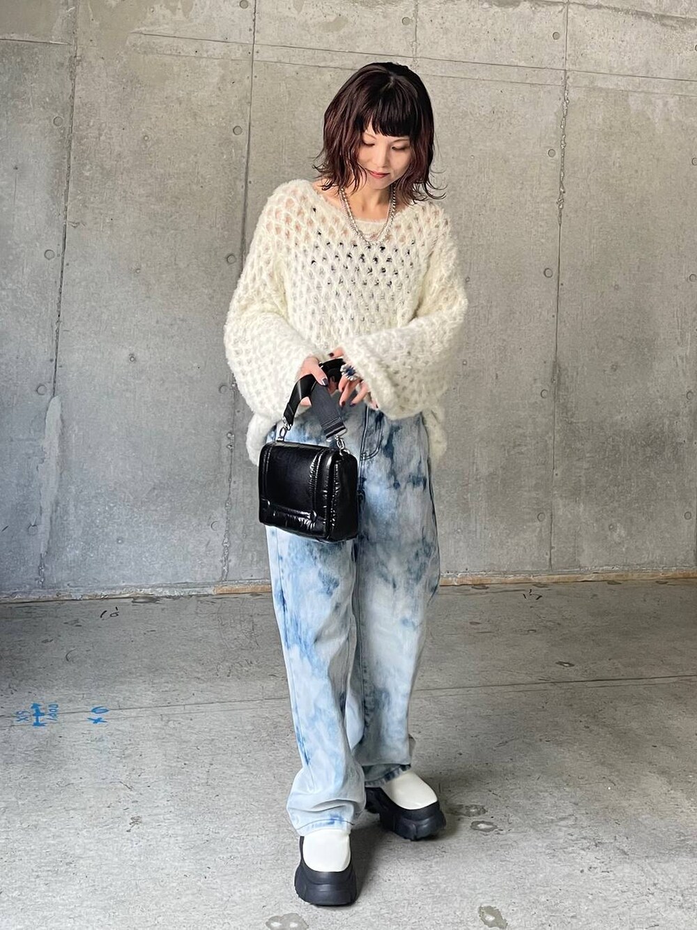 ブルー系のデニムパンツ、ホワイト系のブーツ、ホワイト系のニット/セーターを着用したレディースの秋コーディネートの8枚目の写真