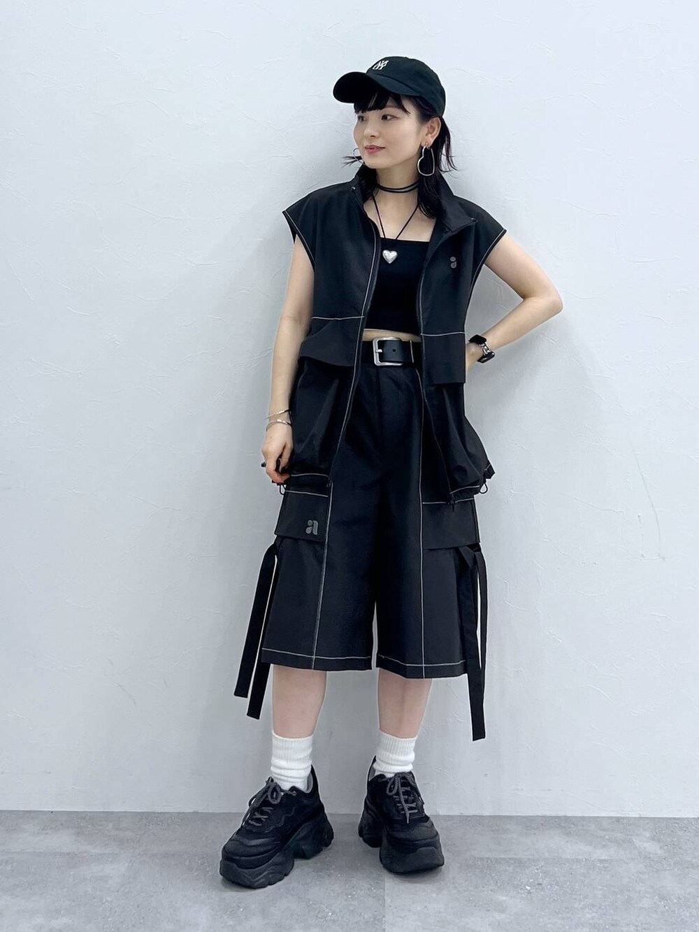 ブラック系のキャミソール、ブラック系のスニーカー、ブラック系のベストを着用したレディースの夏コーディネートの2枚目の写真