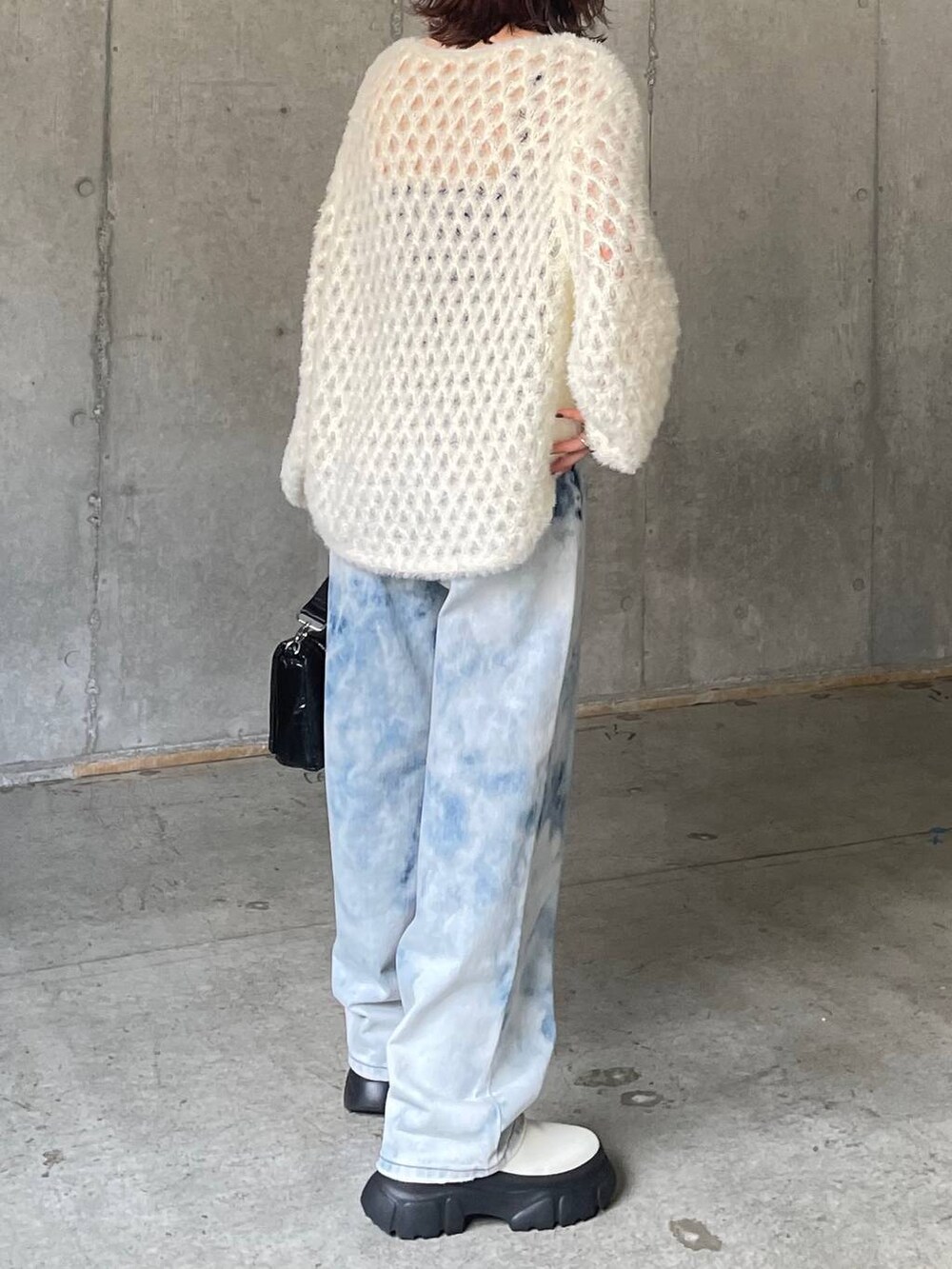 ブルー系のデニムパンツ、ホワイト系のブーツ、ホワイト系のニット/セーターを着用したレディースの秋コーディネートの5枚目の写真