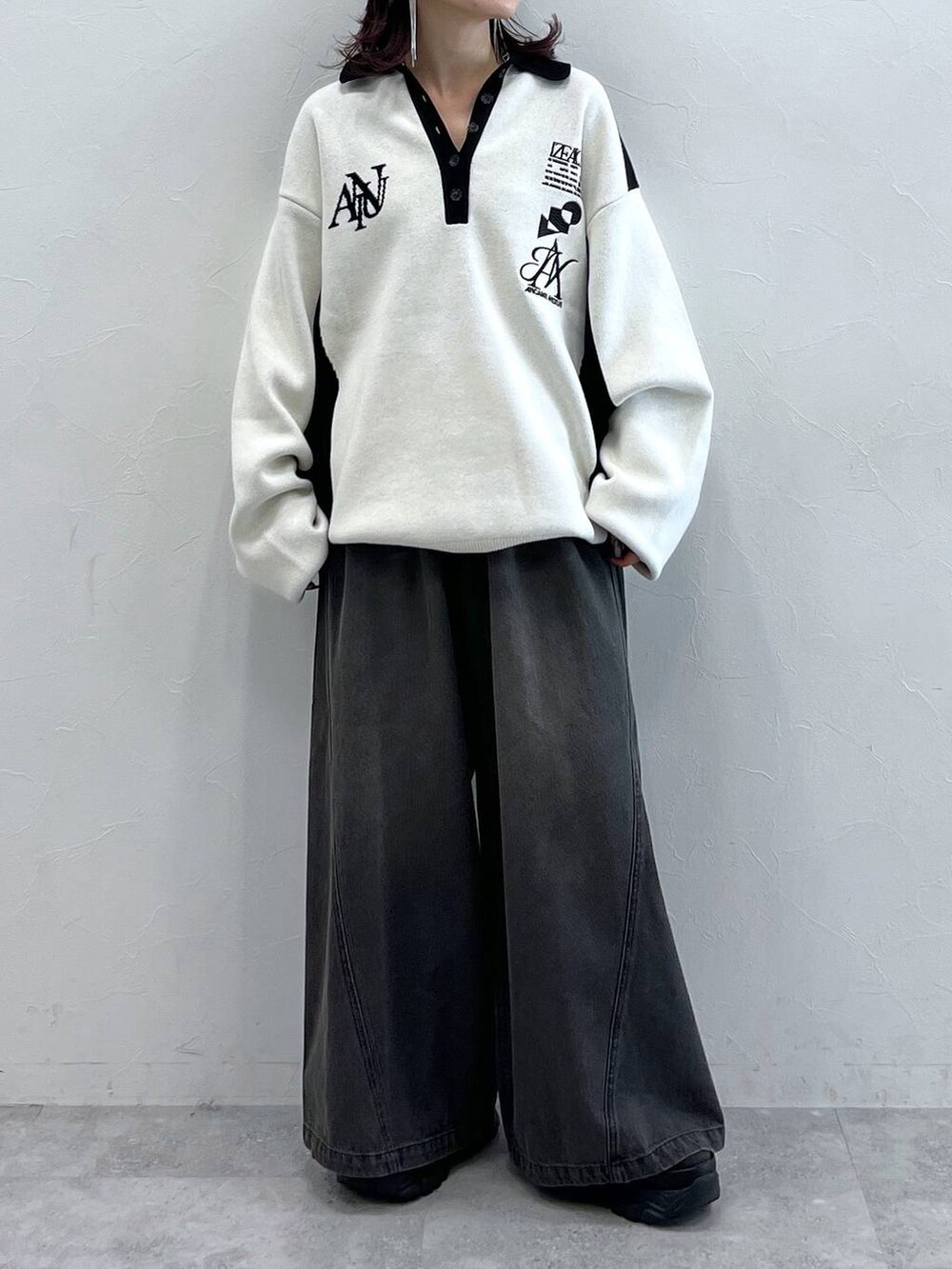 ブラック系のデニムパンツ、ブラック系のニット/セーター、ブラック系のスニーカーを着用したレディースの秋コーディネートの6枚目の写真