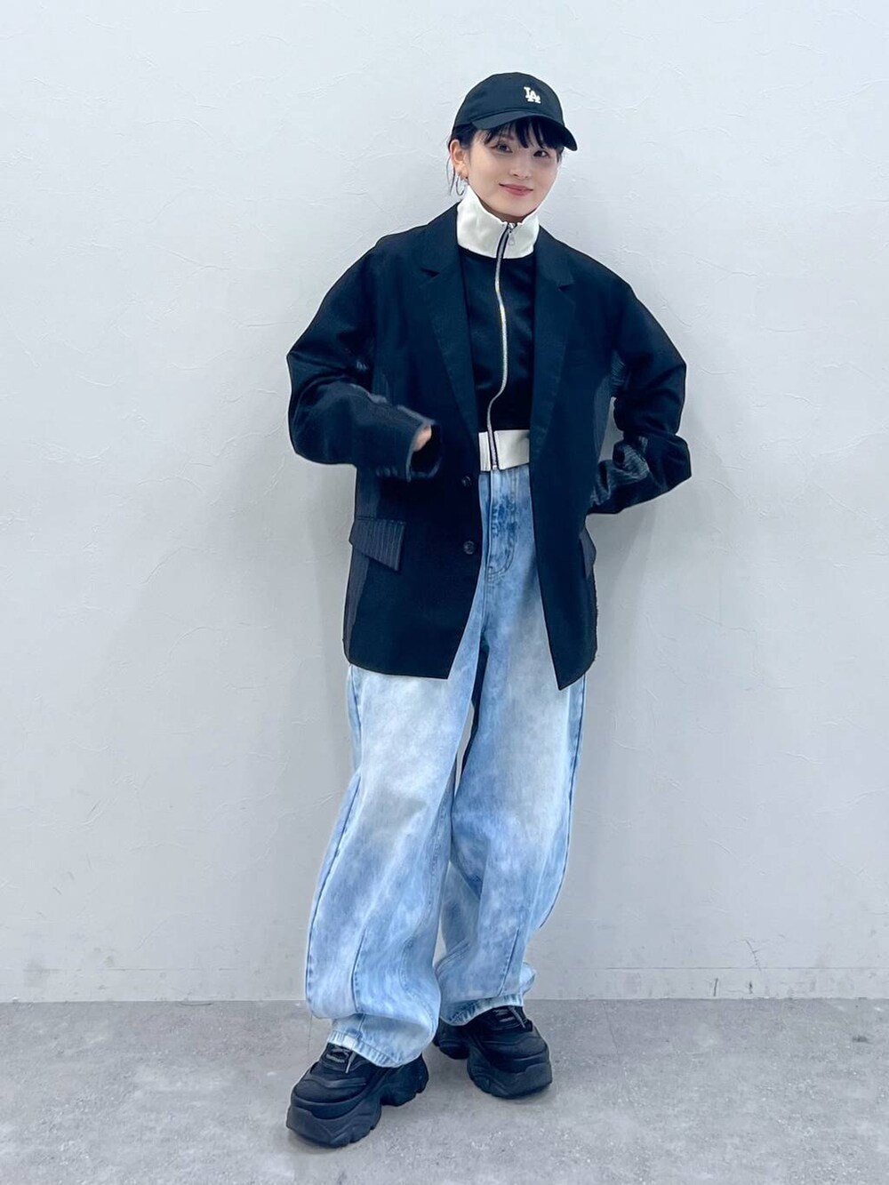 ブラック系のテーラードジャケット、ブラック系のスニーカー、ブラック系のジャージを着用したレディースの春コーディネートの7枚目の写真