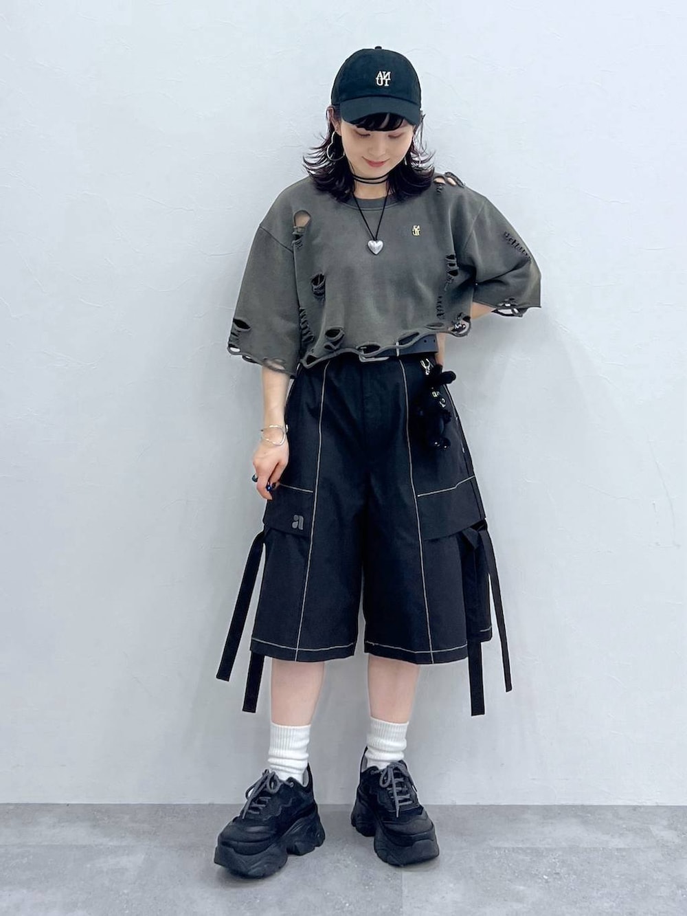 ブラック系のスニーカー、ブラック系のカーゴパンツ、グレー系のTシャツ/カットソーを着用したレディースの夏コーディネートの2枚目の写真
