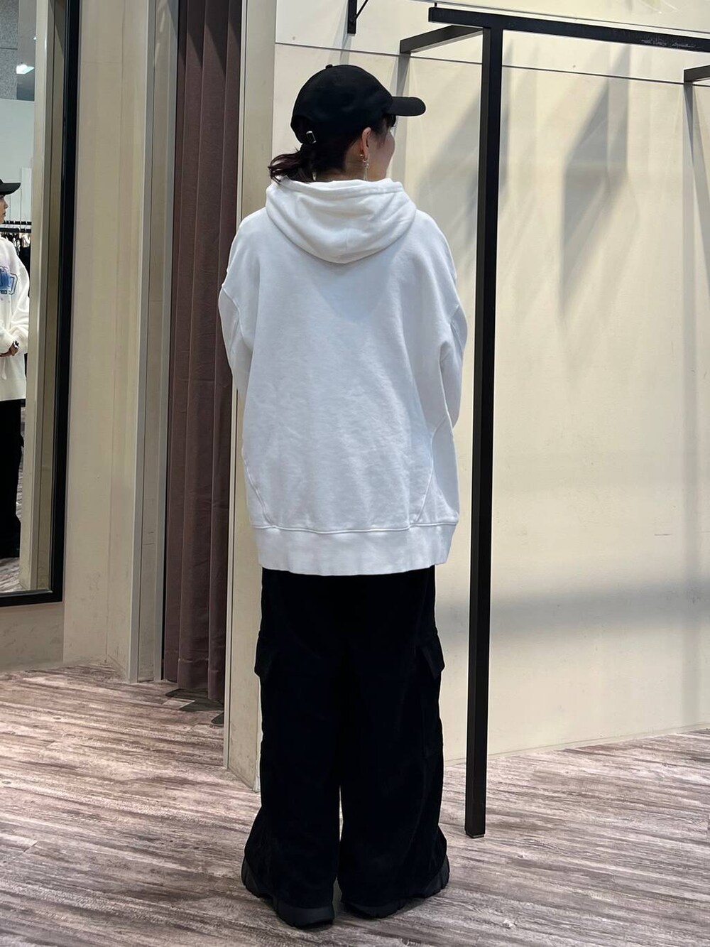 ブラック系のカーゴパンツ、ブラック系のブーツ、ホワイト系のパーカーを着用したレディースの冬コーディネートの5枚目の写真