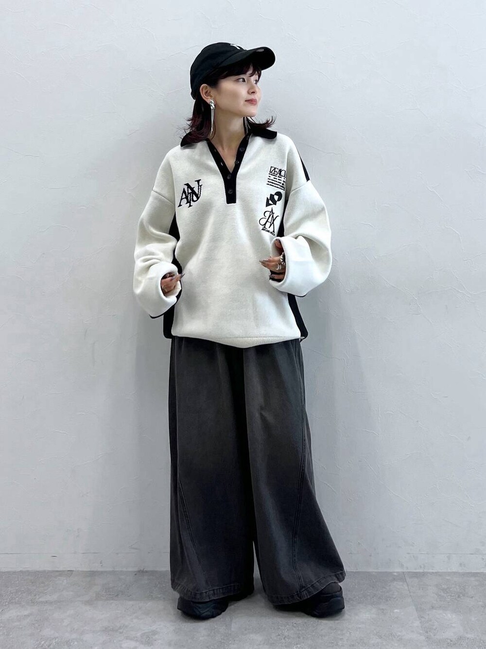 ブラック系のデニムパンツ、ブラック系のニット/セーター、ブラック系のスニーカーを着用したレディースの秋コーディネートの7枚目の写真