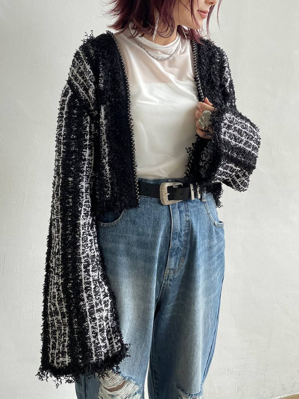 ブルー系のデニムパンツ、ブラック系のカーディガン/ボレロ、ホワイト系のTシャツ/カットソーを着用したレディースの秋コーディネートの6枚目の写真