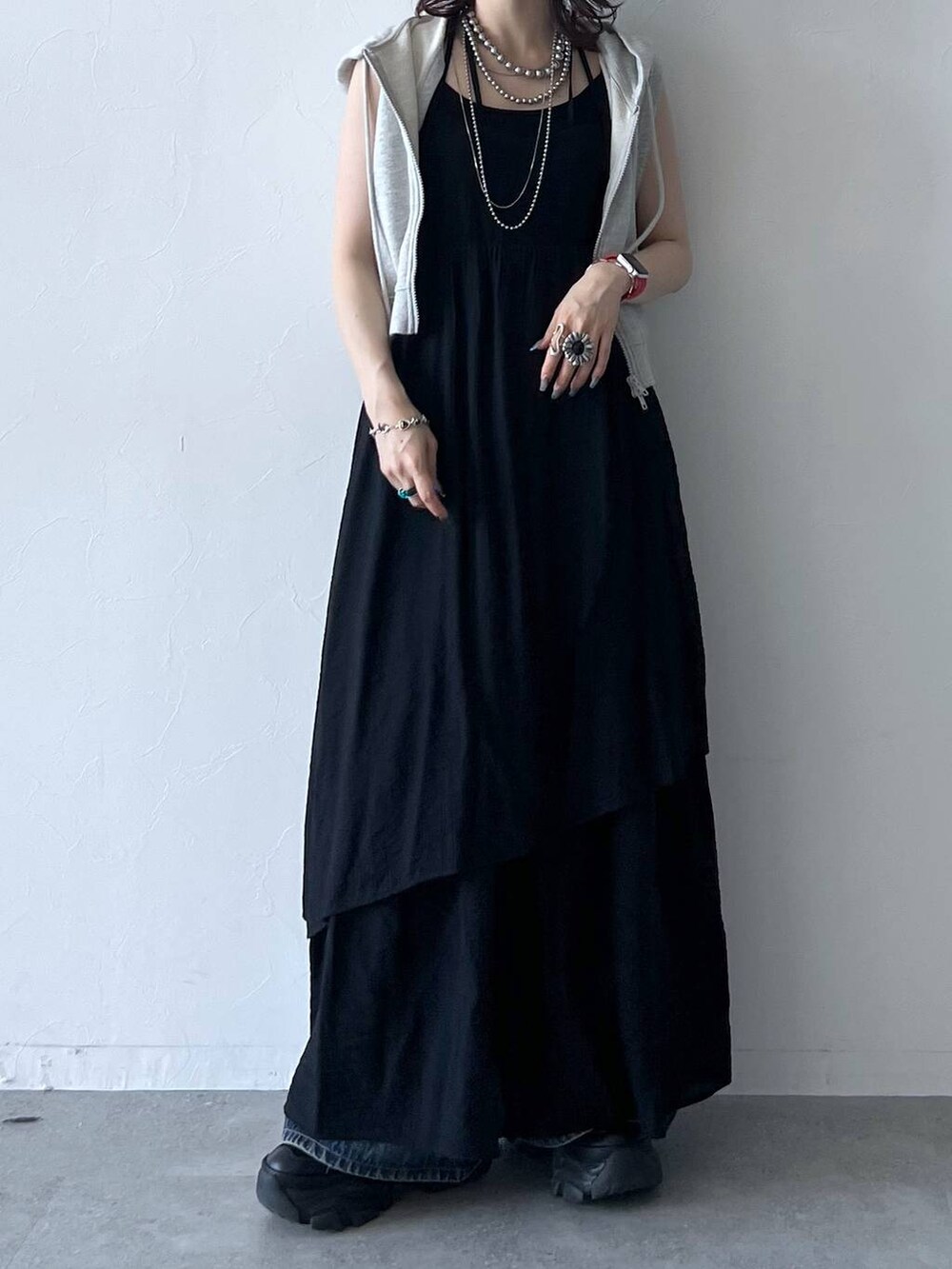 ブラック系のスニーカー、ブルー系のデニムパンツ、ブラック系のキャミソールを着用したレディースの夏コーディネートの5枚目の写真