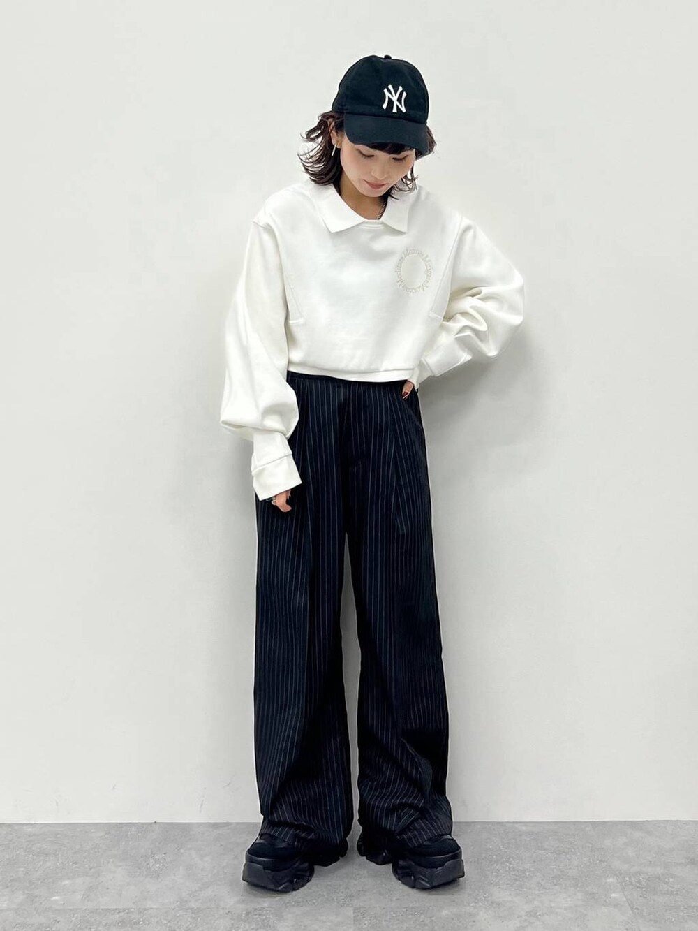 ブラック系のキャミソール、ブラック系のスラックス、ブラック系のスニーカーを着用したレディースの冬コーディネートの5枚目の写真