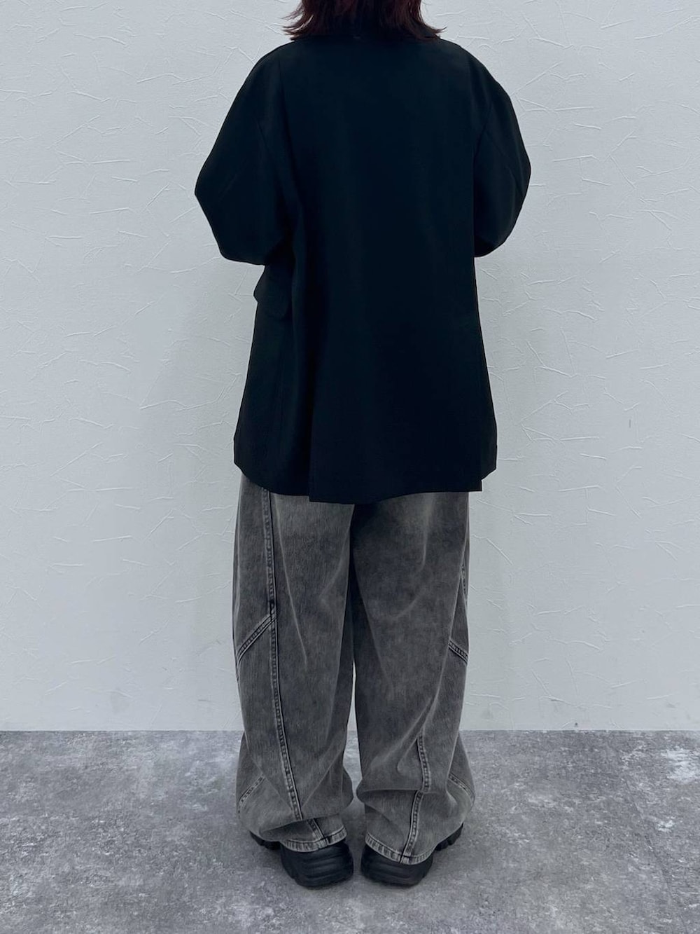 ブラック系のブーツ、ブラック系のテーラードジャケット、ブラック系のデニムパンツを着用したレディースの春コーディネートの5枚目の写真