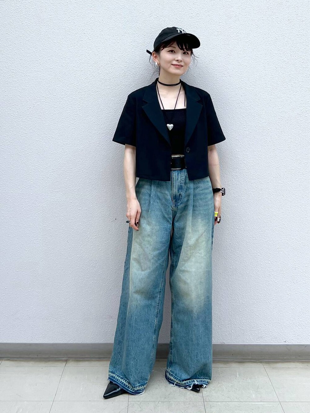 ブルー系のデニムパンツ、ブラック系のパンプス、ブラック系のチョーカーを着用したレディースの夏コーディネートの6枚目の写真